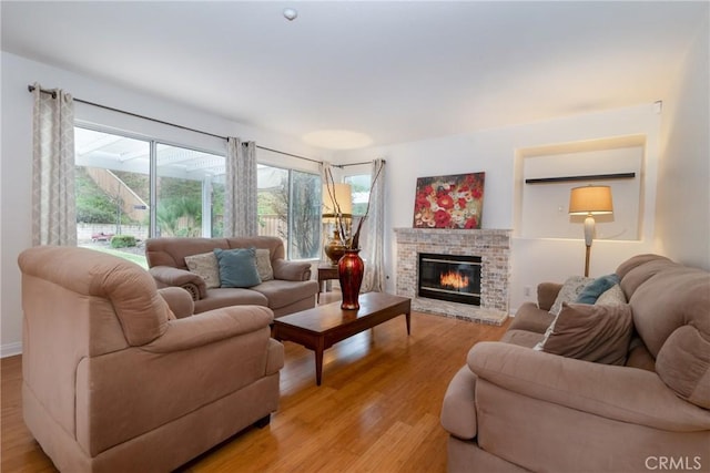 living area with a fireplace and light wood-style floors