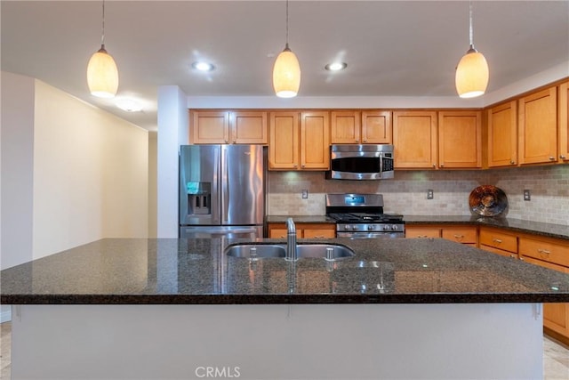 kitchen with a sink, dark stone countertops, backsplash, stainless steel appliances, and brown cabinetry