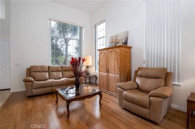 living area with light wood-type flooring and baseboards