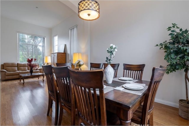 dining space with baseboards and wood finished floors