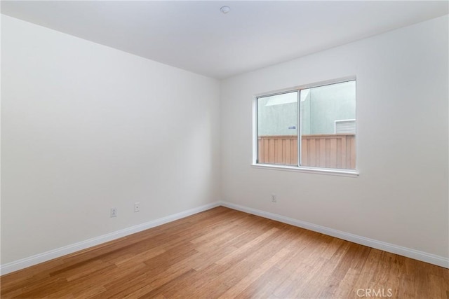 empty room featuring light wood-style floors and baseboards