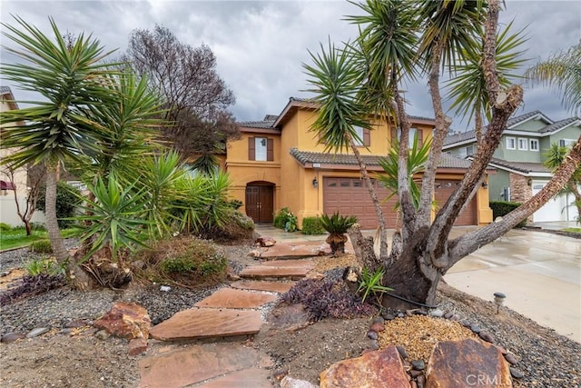 view of front facade with a tiled roof, stucco siding, and driveway