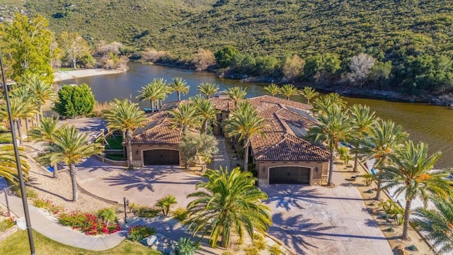 aerial view with a water view and a wooded view