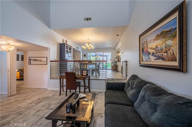 living room with baseboards, marble finish floor, visible vents, and a notable chandelier