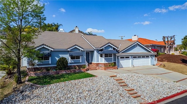 single story home with an attached garage, a tiled roof, a chimney, and concrete driveway