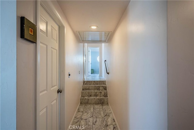 staircase with marble finish floor and baseboards