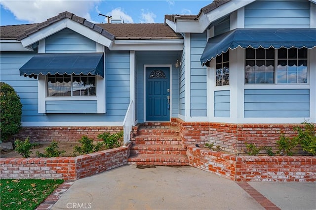 view of exterior entry with brick siding