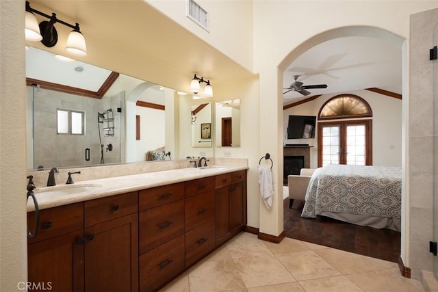 ensuite bathroom featuring ceiling fan, connected bathroom, a sink, visible vents, and a stall shower