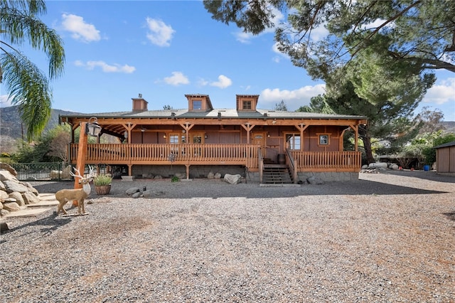 rear view of house with a porch and fence