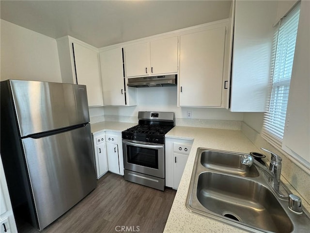 kitchen featuring white cabinets, appliances with stainless steel finishes, light countertops, under cabinet range hood, and a sink