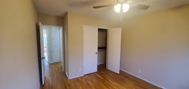 unfurnished bedroom featuring ceiling fan, a closet, wood finished floors, and baseboards