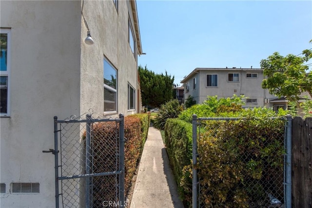 view of home's exterior featuring fence, a gate, and stucco siding