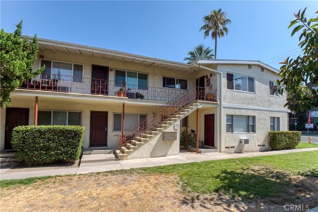 townhome / multi-family property featuring crawl space, stairs, and stucco siding