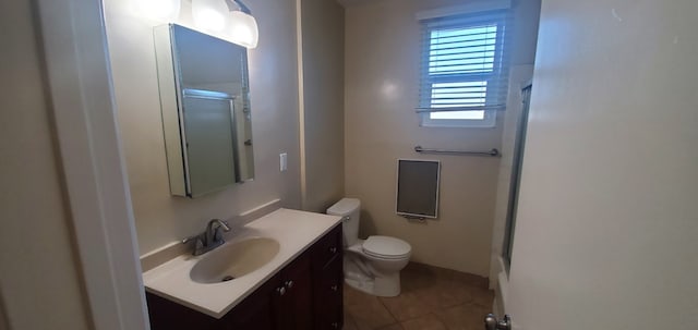 bathroom featuring tile patterned floors, vanity, toilet, and an enclosed shower