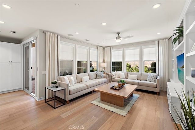 living area featuring light wood finished floors, a ceiling fan, visible vents, and recessed lighting