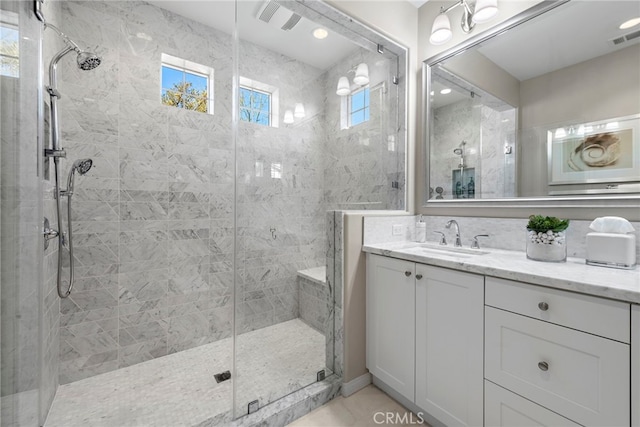 full bath with a stall shower, vanity, and visible vents