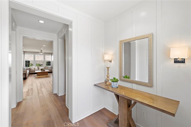 hallway with a decorative wall and wood finished floors