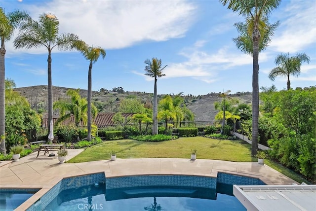 view of swimming pool featuring a yard, a fenced in pool, fence, and a patio