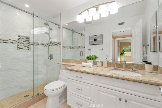 bathroom with toilet, a shower stall, visible vents, and vanity