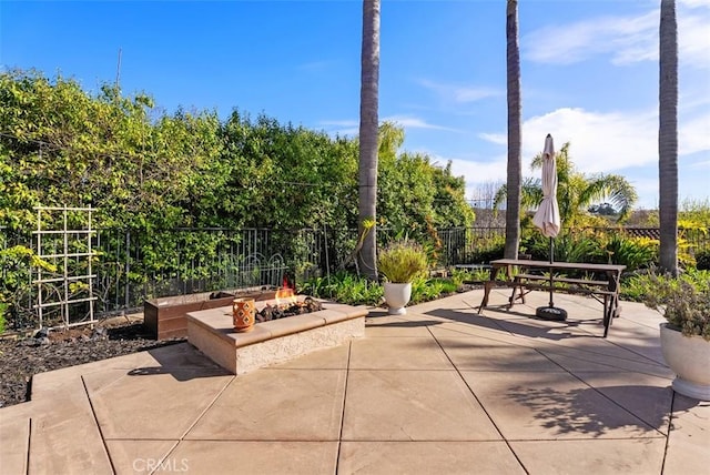 view of patio with an outdoor fire pit, outdoor dining area, and fence