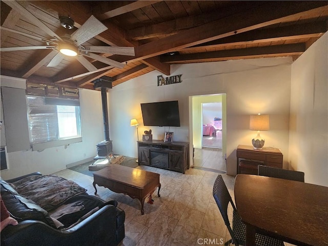 living area featuring wood ceiling, a wood stove, vaulted ceiling with beams, and ceiling fan