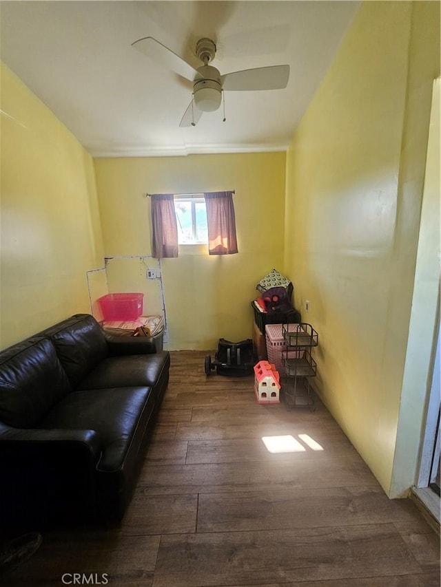 sitting room with wood finished floors and a ceiling fan