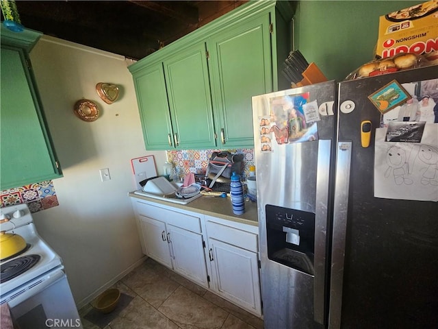 kitchen with white range with electric stovetop, tile patterned flooring, light countertops, stainless steel refrigerator with ice dispenser, and green cabinets