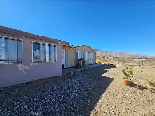 view of side of property featuring a mountain view and stucco siding