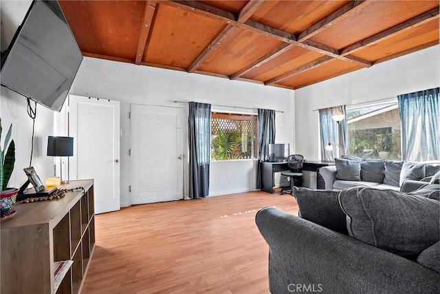 living room with light wood-style floors, beam ceiling, a healthy amount of sunlight, and coffered ceiling