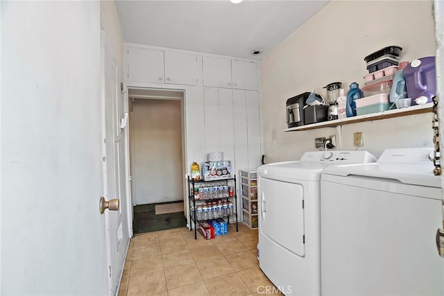 clothes washing area featuring laundry area, light tile patterned floors, and washing machine and clothes dryer