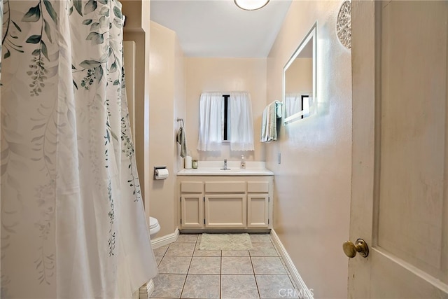 bathroom featuring curtained shower, tile patterned flooring, toilet, vanity, and baseboards