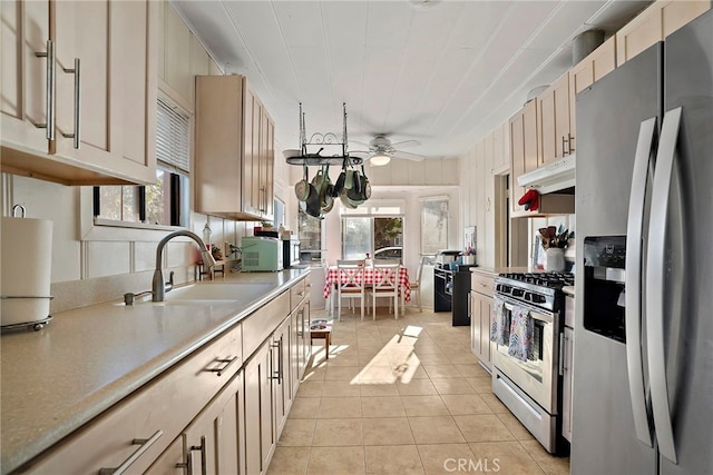 kitchen with appliances with stainless steel finishes, a healthy amount of sunlight, a sink, and under cabinet range hood