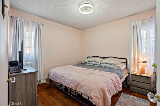 bedroom featuring a textured ceiling and wood finished floors