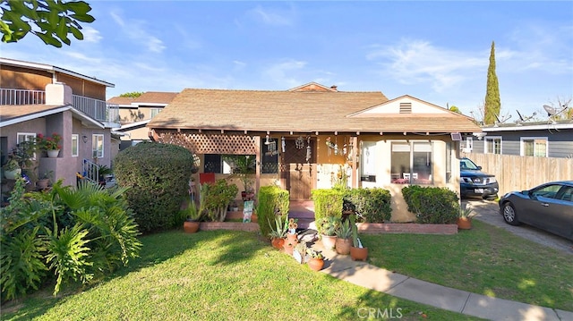 view of front facade with a front yard, fence, and a patio