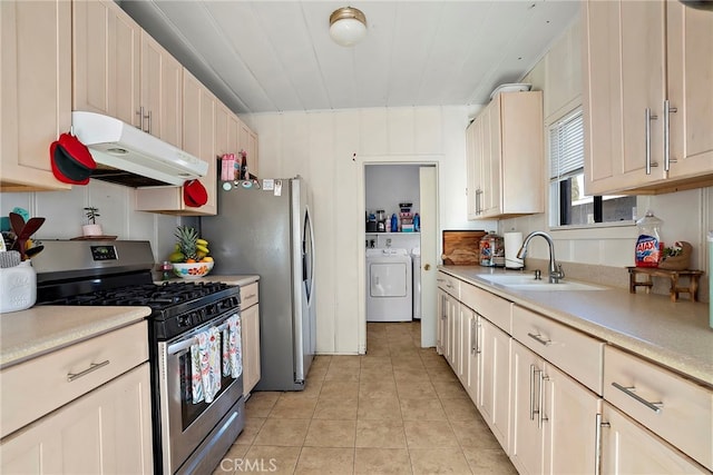 kitchen with stainless steel appliances, light countertops, a sink, independent washer and dryer, and under cabinet range hood