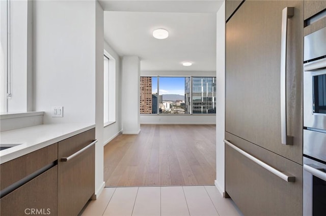 kitchen with light tile patterned floors, stainless steel fridge, and light countertops