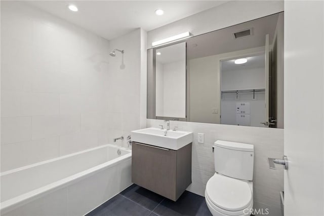 bathroom featuring toilet, vanity, visible vents, tub / shower combination, and tile patterned floors