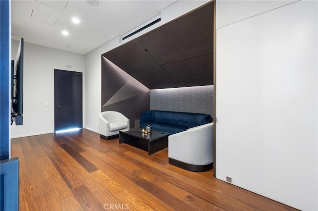 sitting room featuring baseboards, wood finished floors, and recessed lighting