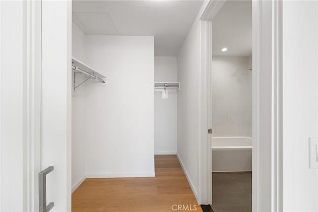 walk in closet with light wood-style flooring