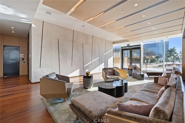 living area with expansive windows, wood finished floors, and recessed lighting