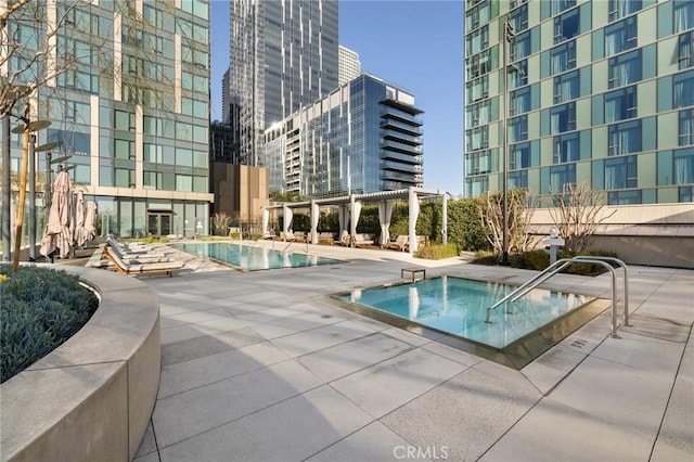 community pool with a community hot tub, a pergola, and a patio