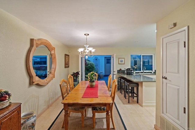 dining space with a chandelier, light wood-style flooring, and visible vents