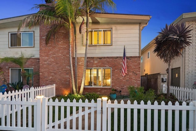 view of home's exterior with a fenced front yard and brick siding