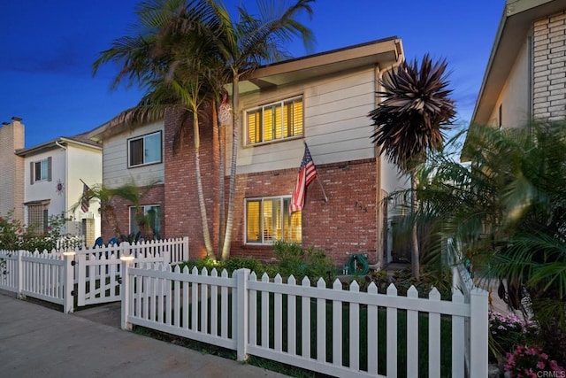 view of front of house with a fenced front yard and brick siding