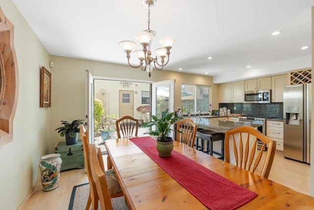 dining room with a chandelier, light wood-type flooring, and recessed lighting