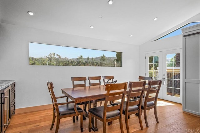 dining room featuring lofted ceiling, light wood-style flooring, recessed lighting, and french doors