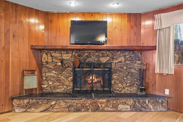 room details featuring wood walls, a fireplace, and wood finished floors