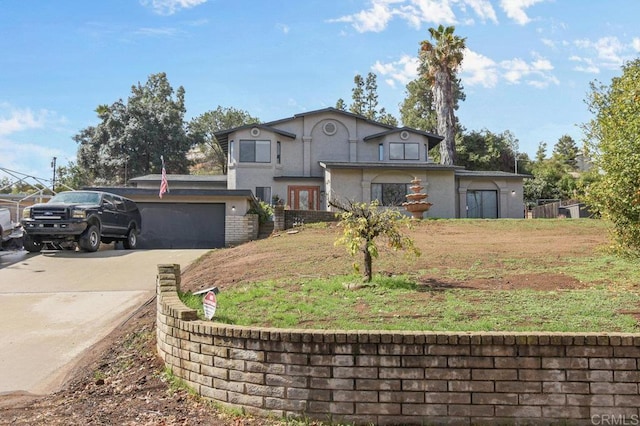 traditional home featuring concrete driveway, brick siding, an attached garage, and stucco siding