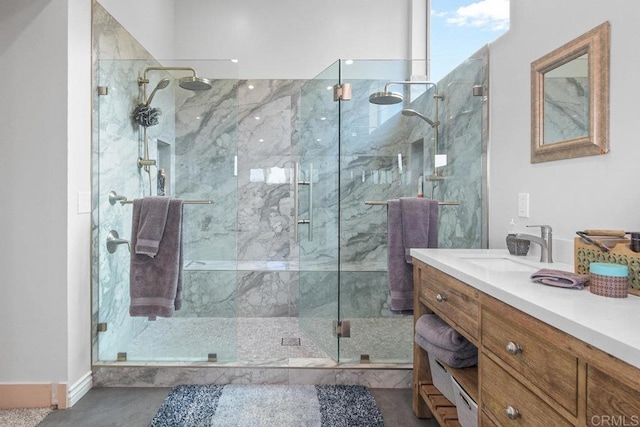 bathroom featuring a marble finish shower and vanity