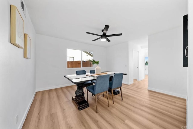 dining space with light wood-type flooring, visible vents, baseboards, and a ceiling fan